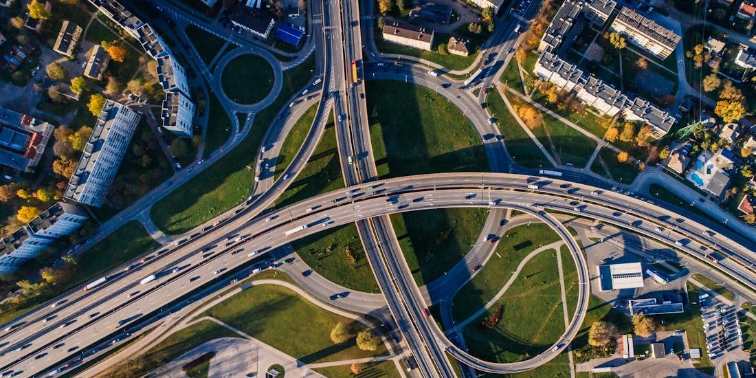 Aerial shot of a complex highway intersection in a vibrant urban cityscape.